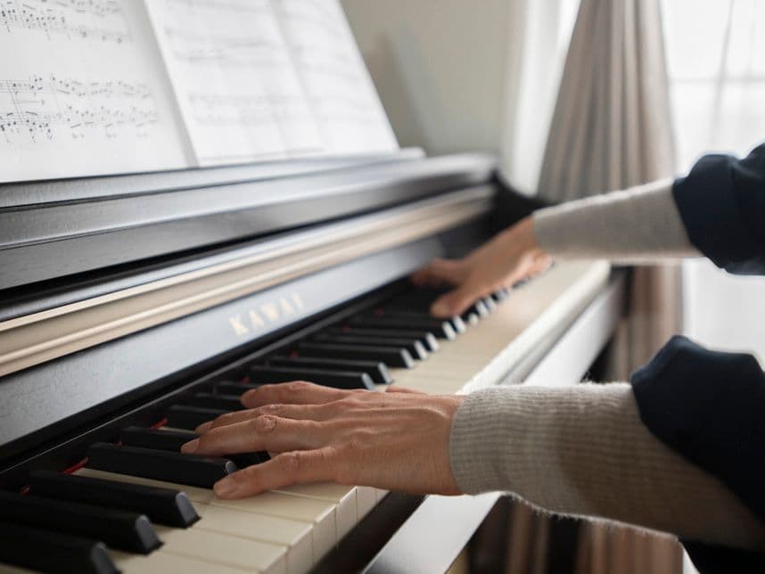 中古マンションのリノベーション後のリビングのピアノを弾く女性の手